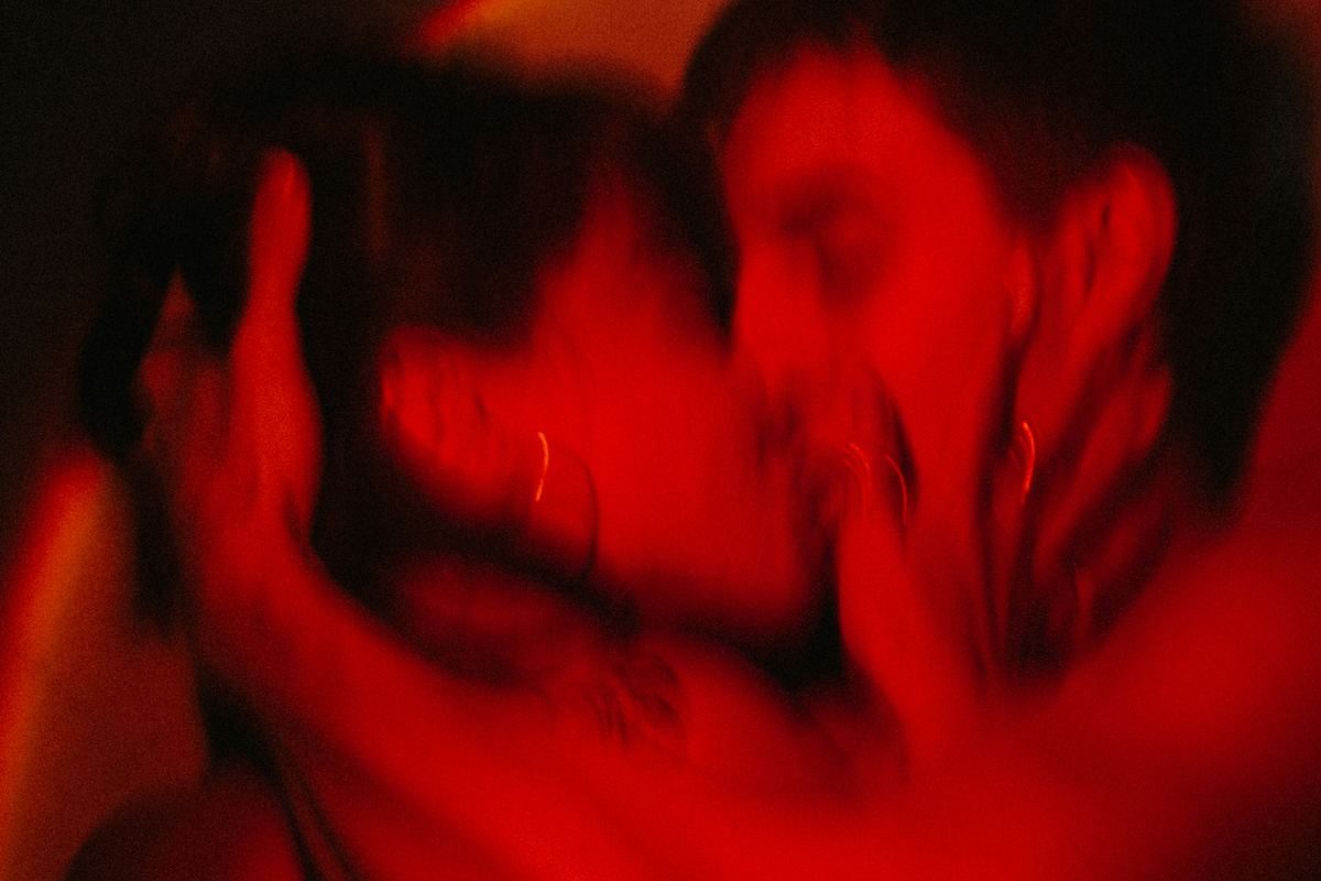 A couple kissing in warm red light