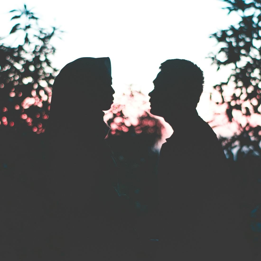 Two people facing each other in silhouette
